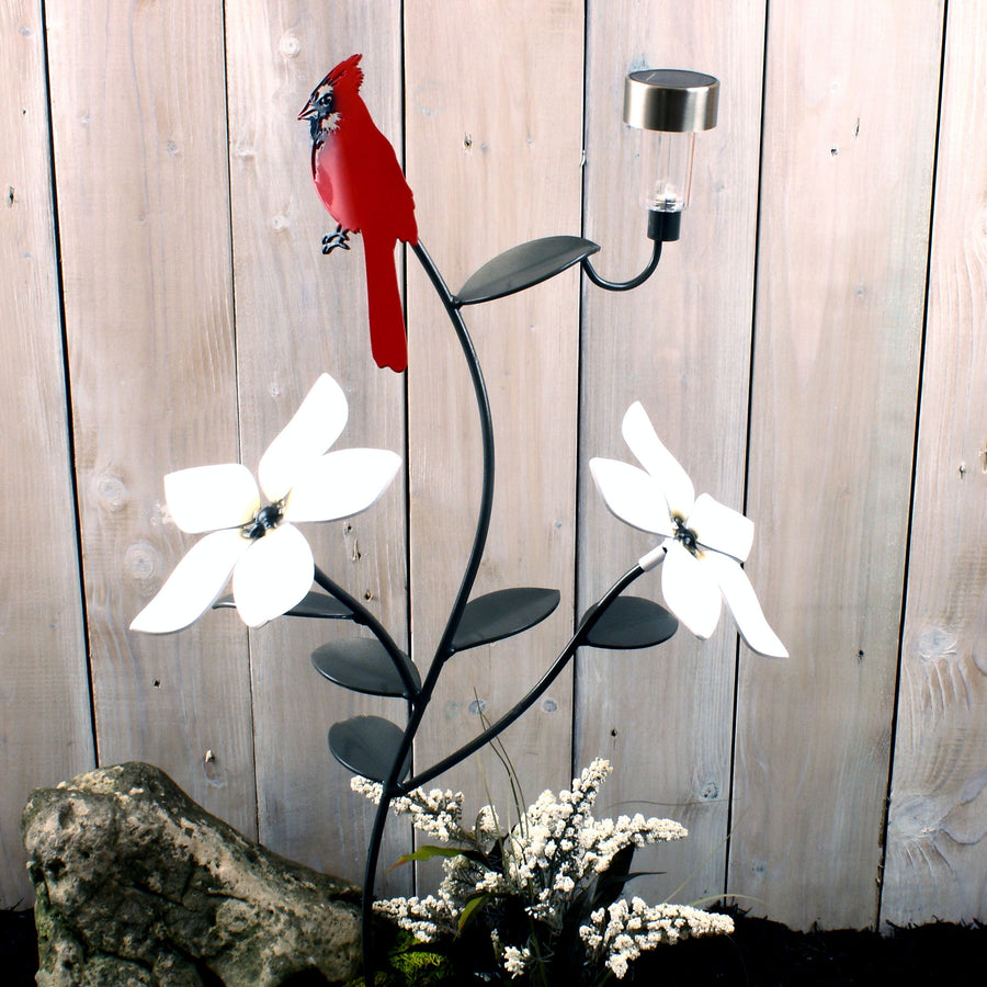 Red Cardinal with solar light and two flowers